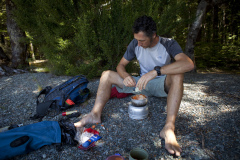 Dallas Hewett preparing a meal at Mavora Lakes, Southland, New Zealand.