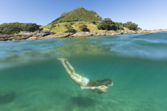 Kristin Crook swims in the sunshine at the beach, Mount Maunganui, Bay of Plenty, New Zealand.