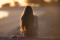 Kristin relaxes in the sunshine at the beach, Mount Maunganui, Bay of Plenty, New Zealand.