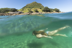 Kristin relaxes in the sunshine at the beach, Mount Maunganui, Bay of Plenty, New Zealand.